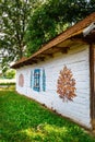 Colourful house with flowers painted on walls and sundial in the village of Zalipie, Poland. It
