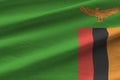 Zambia flag with big folds waving close up under the studio light indoors. The official symbols and colors in banner Royalty Free Stock Photo
