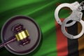 Zambia flag with judge mallet and handcuffs in dark room. Concept of criminal and punishment, background for judgement Royalty Free Stock Photo