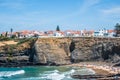 Zambujeira do Mar PORTUGAL - 13 August 2019 - View of typical village houses with cliff by the sea, beach day with several familie