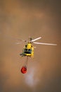 Fire fighter helicopter against dark smoke with water tank Royalty Free Stock Photo