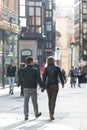 A couple walks hand in hand on a street