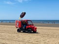 View on red vehicle selling ice cream on beach of dutch north sea in summer