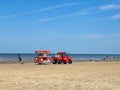 View on red vehicle with trailer selling ice cream on beach of dutch north sea in summer