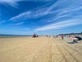 View on sand beach with umbrellas at dutch north sea in summer with blue sky and few cirrus clouds Royalty Free Stock Photo