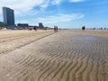 View on sand beach with umbrellas at dutch north sea in summer with blue sky and few cirrus clouds Royalty Free Stock Photo