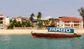Zanzibar - fisherboat with Stone Town in the background. Jambo is the word used to say Hello. Royalty free photo