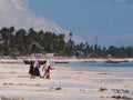 Zanzibar locals walking out to sea at low tide Royalty Free Stock Photo