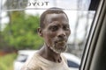 African poor man in a street by a passing car asks for money for food on the island of Zanzibar, Tanzania, East Africa, close up