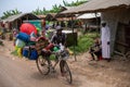 Zanzibar, Tanzania - JANUARY 2020: Black African Man with Bicycle Loaded with Good and Household Tools on Village