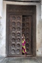 African girl against an old carved door in Zanzibar