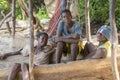 Three african young guys seat on wooden boat on the beach of Zanzibar island, Tanzania, East Africa