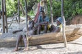 Three african young guys seat on wooden boat on the beach of Zanzibar island, Tanzania, East Africa