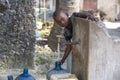 African boy fills the canister with tap water on a street in Zanzibar Island, Tanzania, East Africa