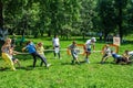 Children competing in tug of war game in a city park