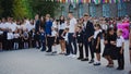 Zaporizhia, Ukraine - September 1, 2018: high school students hold first-graders by the hands and stand on an open-air ruler on