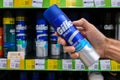 A man\'s hand holds a Gillette Series shaving gel against the background of a shelf with Gillette brand products in a store