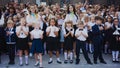 Zaporozhye, Ukraine - September 1, 2018: first-graders stand on a ruler in the open air with teachers and high school students on