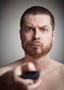 Zapping - annoyed man with tv remote control Royalty Free Stock Photo