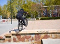 Zaragoza , Spain; 03 23 2019 : sport man wearing helmet, t-shirt, gloves and trousers in black riding a bmx bicycle getting up the Royalty Free Stock Photo