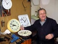 Clockmaker repairs large street clocks