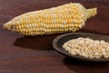 Zea mays - Wooden bowl with raw corn kernels, on wooden background Royalty Free Stock Photo