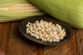Zea mays - Wooden bowl with raw corn kernels, on wooden background Royalty Free Stock Photo
