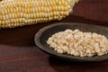 Zea mays - Wooden bowl with raw corn kernels, on wooden background Royalty Free Stock Photo
