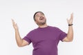 A zealous middle aged man proclaims his faith, raising his hands up. Wearing a purple waffle shirt, Isolated on a white background