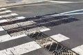 Zebra crossing and sewer manholes at asphalt road Royalty Free Stock Photo