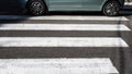 Zebra pedestrian marking with car,close-up, passing car on zebra crossing. Royalty Free Stock Photo