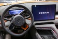 Zeekr 001 EV car interior - dashboard, player, steering wheel with logo and buttons, speedometer and tachometer. Royalty Free Stock Photo