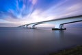 Zeeland Bridge - long white bridge over the river, beautiful blue sky with dynamic clouds. Long time, calm water of the Royalty Free Stock Photo