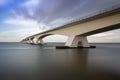 Zeeland Bridge - long white bridge over the river, beautiful blue sky with dynamic clouds. Long time, calm water of the