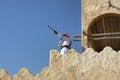 young man holding his rifle while standing on high Wall