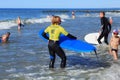 ZELENOGRADSK, KALININGRAD REGION, RUSSIA - JULY 29, 2017: Unknown surfers with surfboard standing near unknown children.