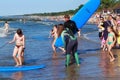 ZELENOGRADSK, KALININGRAD REGION, RUSSIA - JULY 29, 2017: Unknown surfers with surfboard standing on a sandy beach.