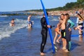 ZELENOGRADSK, KALININGRAD REGION, RUSSIA - JULY 29, 2017: Unknown surfers with surfboard standing on a sandy beach.