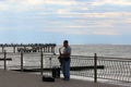 Saxophonist playing music on the promenade Baltic Shore Mans head on natural sky and Sea background