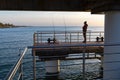 Zelenogradsk, Russia - May 08, 2019: Man fishing at the pier. Baltic sea sunset