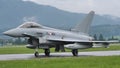 Combat military jet aircraft taxi on the runway in a raining day. Copy Space.