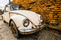 Zemun, Serbia - 17 February 2019 - Old Rusted White Volkswagen Beetle Parked Next To Orange Brick Wall