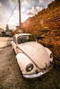 Zemun, Serbia - 17 February 2019 - Old rusted white Volkswagen Beetle parked next to orange brick wall Royalty Free Stock Photo