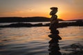 Zen balanced stones stacked on sea coast at sunset. Balance and equilibrium concept