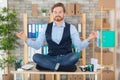 zen businessman doing yoga meditation on office desk Royalty Free Stock Photo