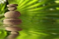 Zen composition with balancing pebbles and Palm tree leaf