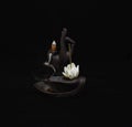 Zen figure with incense and smoke in dark background