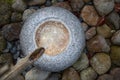 Zen fountain from above made of granite stone with bamboo water inlet and background made of large pebbles Royalty Free Stock Photo