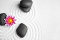 Zen garden. Beautiful lotus flower and stones on sand, flat lay Royalty Free Stock Photo