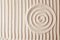 Zen garden pattern on sand as background, top view Royalty Free Stock Photo